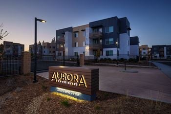 The aurora apartments sign at dusk